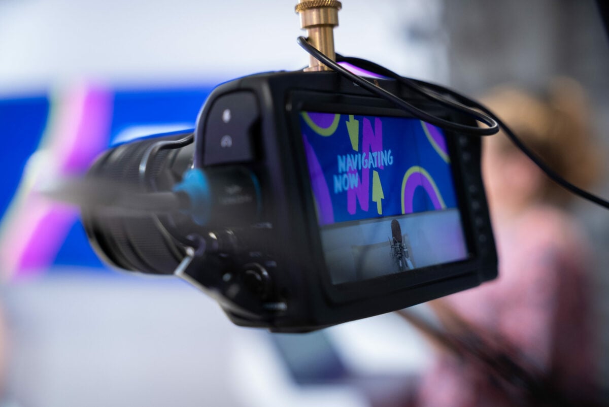 Close-up of a camera's monitor screen displaying a colorful background with the text 